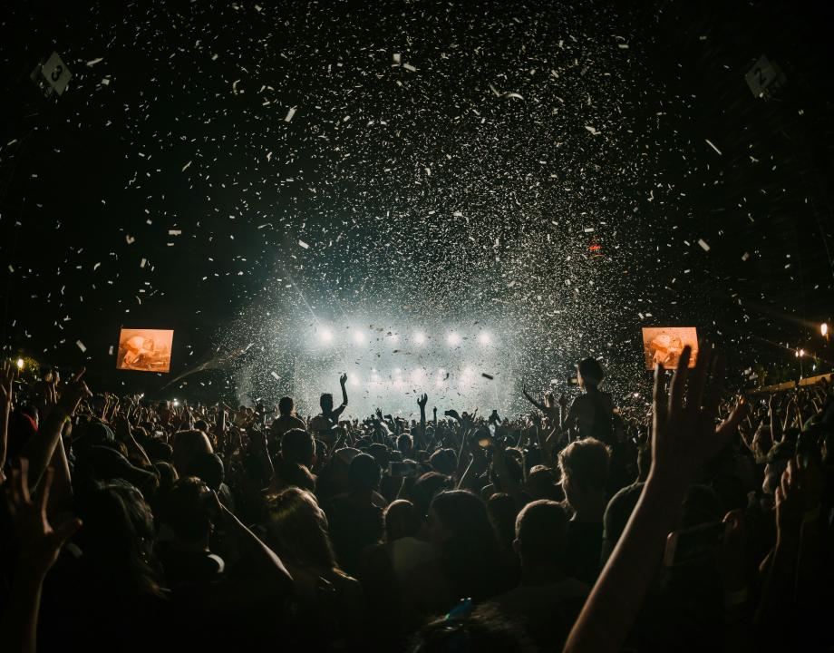 veel mensen in een donkere hal die bij een evenement zijn