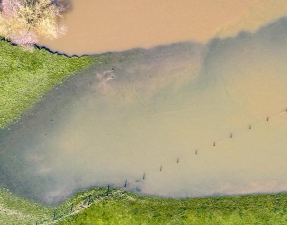 Weiland van boven af gezien overstroomd met rivierwater